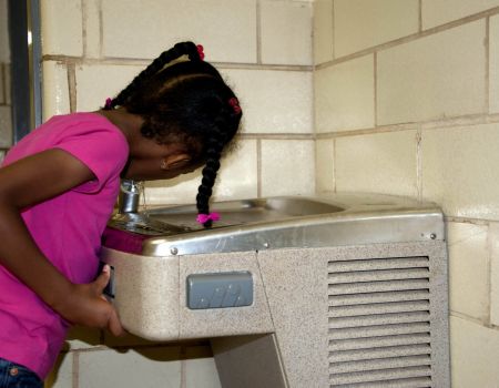 girl drinking from water fountain