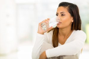 young woman drinking fluoridated water